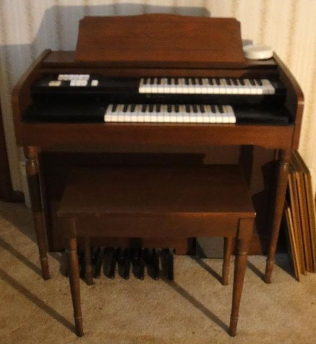 Most electronic home organs built after World War II were compact, relatively inexpensive, and built into a configuration called a spinet organ, which first appeared in 1949.
These instruments presented simplified controls and functions that were both less expensive to produce and less intimidating to learn (photo shows a Lowrey Starlet model, c. 1961, the instrument on which one classically trained organist first began his journey in organ playing).
The 2 keyboards, or manuals, were typically offset and at least an octave shorter than is normal for organs, inviting but not requiring the new organist to dedicate the right hand to the upper manual and the left hand to the lower, rather than using both hands on a single manual.
Since the upper manual typically omitted the bass, and the lower manual typically omitted the treble, this seemed designed to encourage the pianist, who was accustomed to a single keyboard, to make use of both manuals.
Stops on these instruments were typically few in number and frequently named after orchestral instruments that they could, at best, only roughly approximate.
The loudspeakers were housed within the main instrument.
The pedalboard made up of 13 stub pedals normally spanned only a single octave, was often incapable of playing more than one note at a time, and was effectively playable only with the left foot.
With the expression pedal located to the right and either partly or fully recessed within the kickboard, it was conveniently reachable only with the right foot.
These limitations, combined with the shortened manuals, made the spinet organ all but useless for performing or practicing classic organ music; but at the same time it allowed the novice home organist to explore the challenge and flexibility of simultaneously playing 3 keyboards (2 hands and 1 foot).
This arrangement spawned a style of casual organist who would naturally rest the right foot on the expression pedal the entire time, unlike classically trained organists [See blog, 
