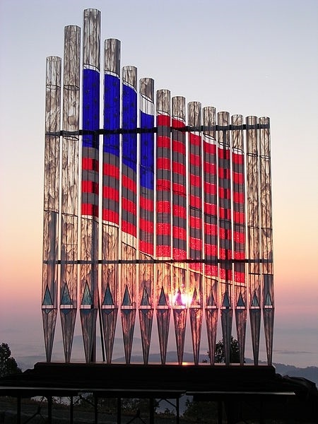 This very intriguing American flag rank of glass organ pipes was created in response to the tragedy of the terrorist attack on the USA on September 11, 2001.
This series of 14 real pipe organ pipes were made of glass using kilnworking, stained glass techniques, and delicate pipe organ engineering.
The pipes were innovated, designed, and created by a certified pipe organ builder and master craftsman, Xaver Wilhelmy.
He has created the first sets of glass pipe organ pipes in the world, and this rank of pipes viewed at sunrise in the Blue Ridge mountains (photo) is one of 2 existing glass organ pipe ranks in the world at this time.
The series of pipes comes with a wooden base that contains the technical inner works of a pipe organ, and is controlled with a portable keyboard unit; yes, the pipes actually play; they were professionally voiced and tuned by Wilhelmy.
The pipes took this builder and his crew 18 months to create from conception to completion in June 2004.

